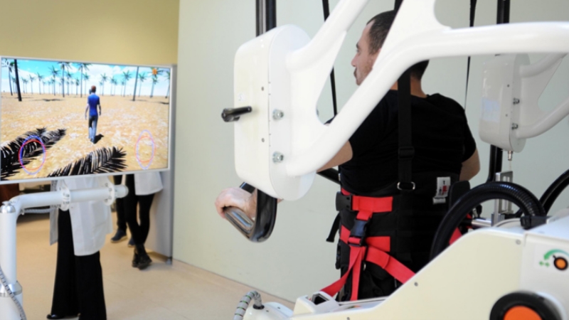 Gribin tetiklediği sendromla felç geçirdi, robotla yürümeye çalışıyor